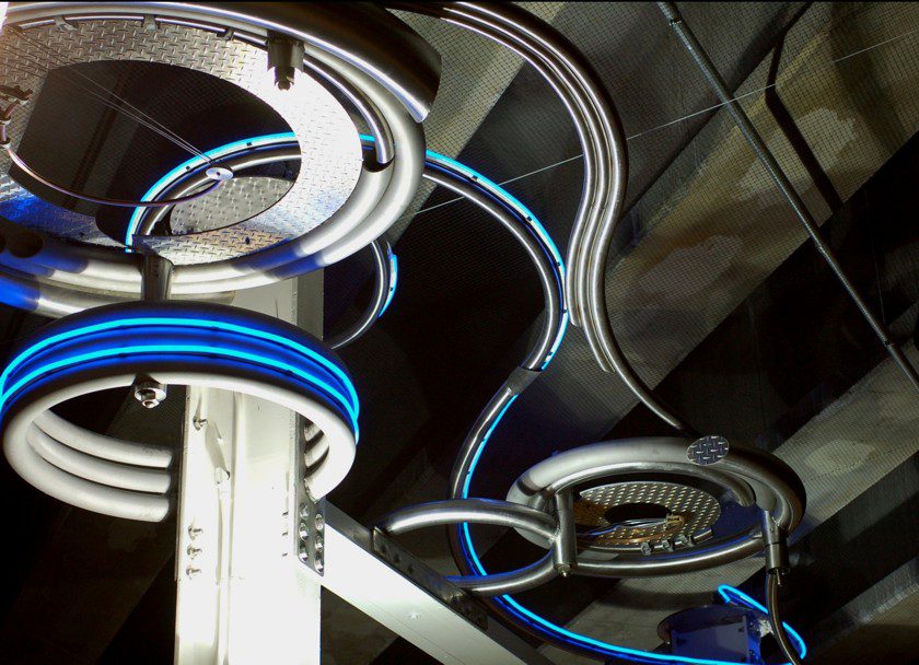 A Metallic Roller With Blue Light and Conveyer Lines in Ceiling