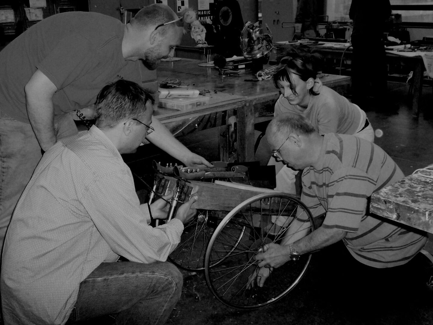 A group of people participating in Ira Sherman Workshops, working on a wheel chair.