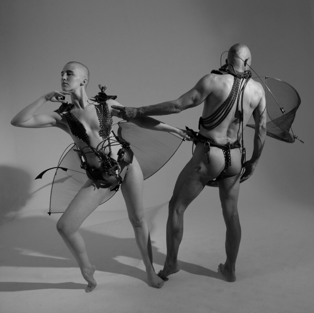 A black and white photo of two dancers in elaborate costumes.