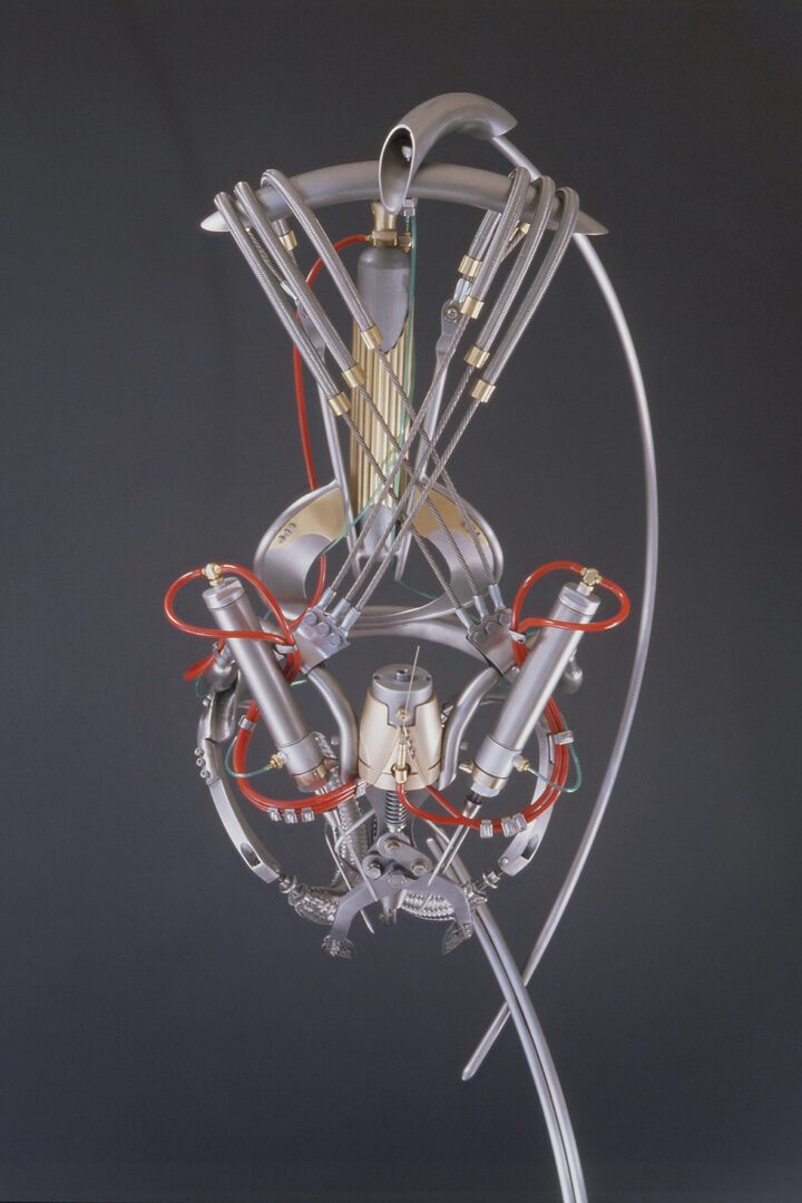 An interactive sculpture featuring a red wire attached to a model machine.