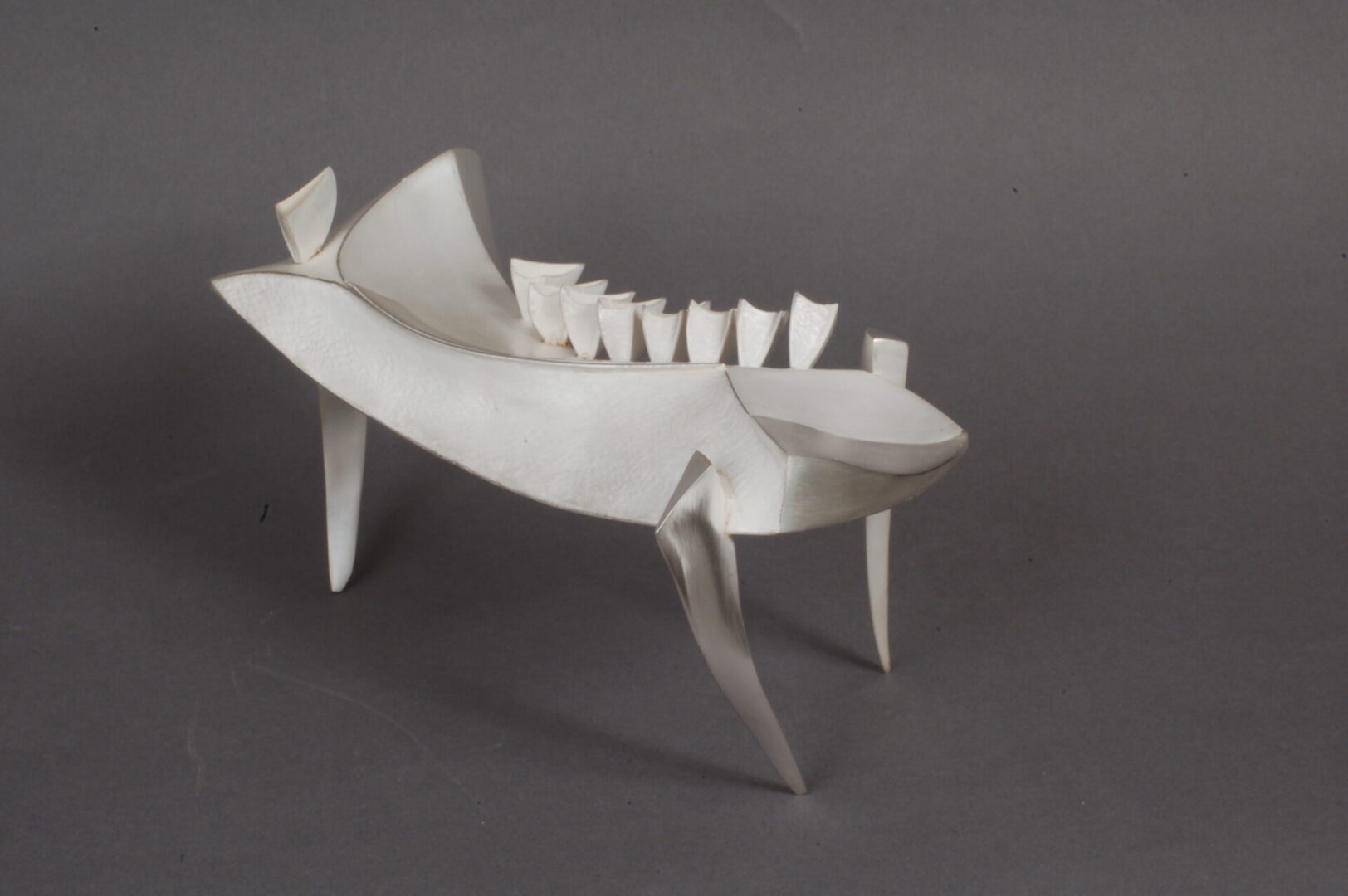 A fish sculpture on a grey background by Ira Sherman.