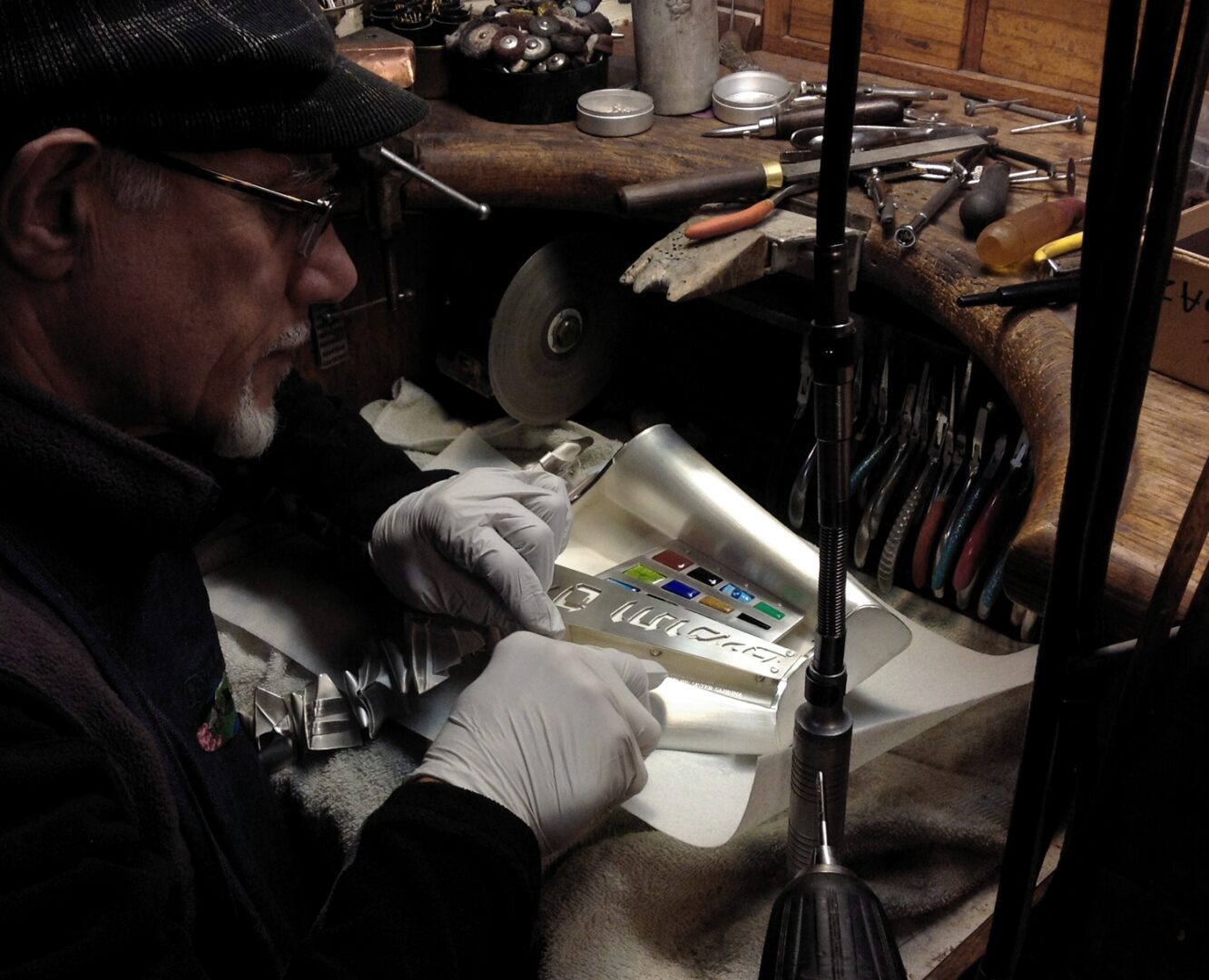 A man is crafting a piece of metal for Ira Sherman Jewelry.