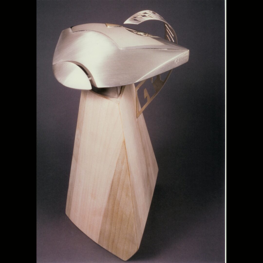 This wooden sculpture, adorned with a hat on top, is reminiscent of Ira Sherman's intricate jewelry designs.