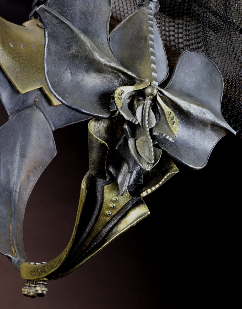 A metal mask with a flower on it.