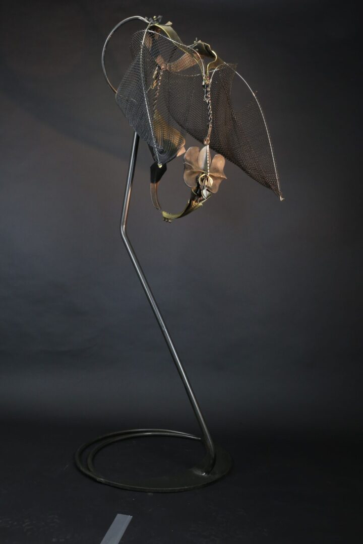 A metal lamp with a bat on it.