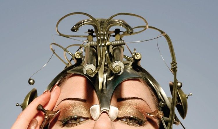 A woman with a metal headpiece on her face.
