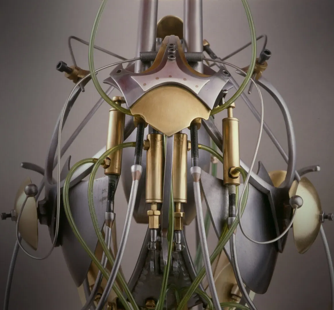 A mechanized sculpture with numerous wires connected to it, created by Ira Sherman.