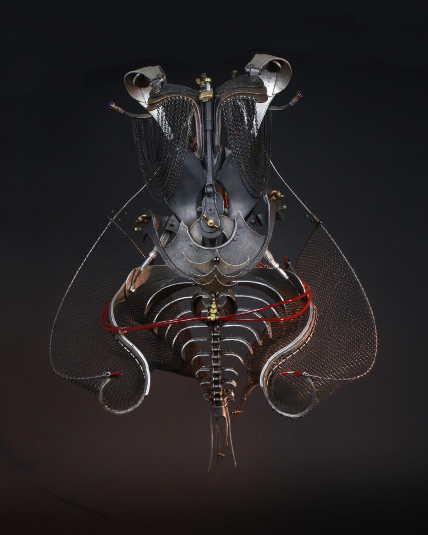 A mechanized sculpture by Ira Sherman featuring a metal body and wires.