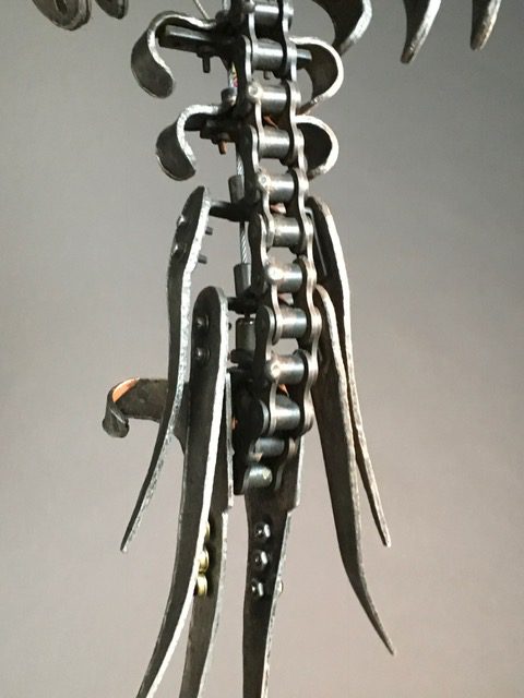 A metal sculpture with a chain attached to it.